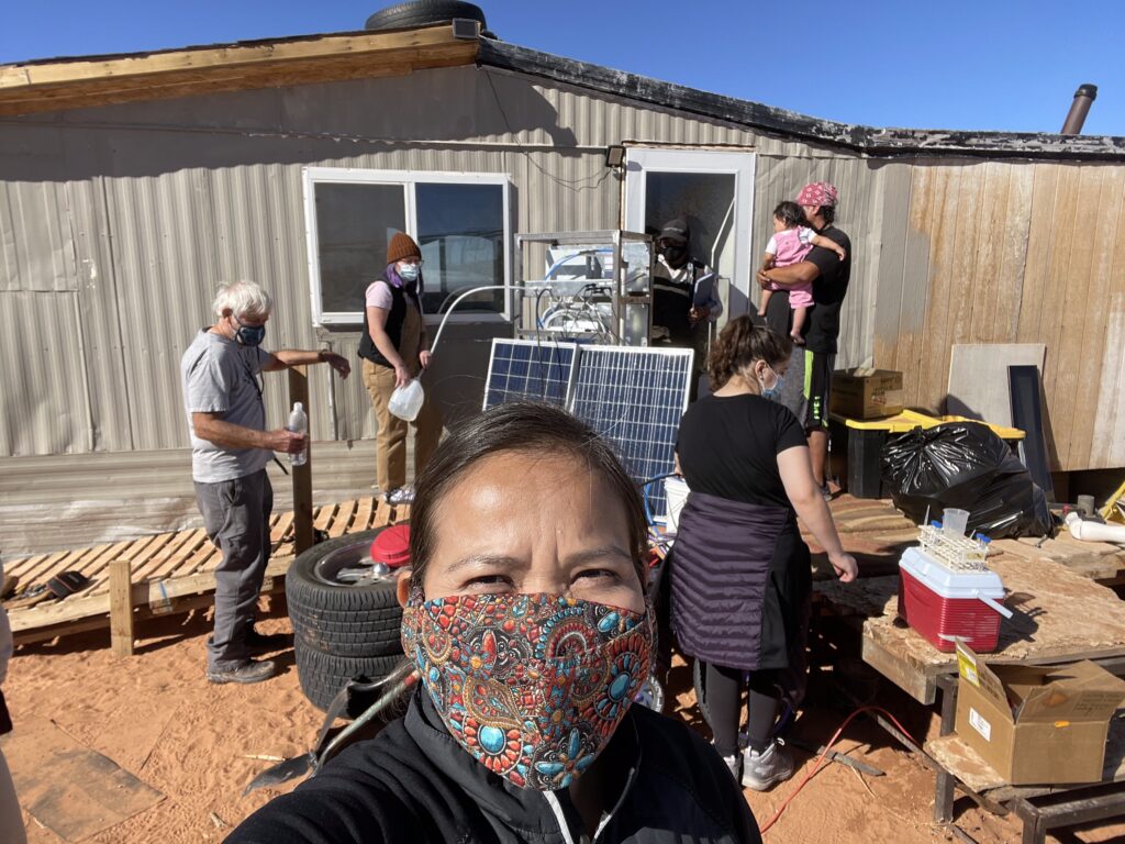 Karletta Chief wearing a mask taking a selfie while assisting with a solar project